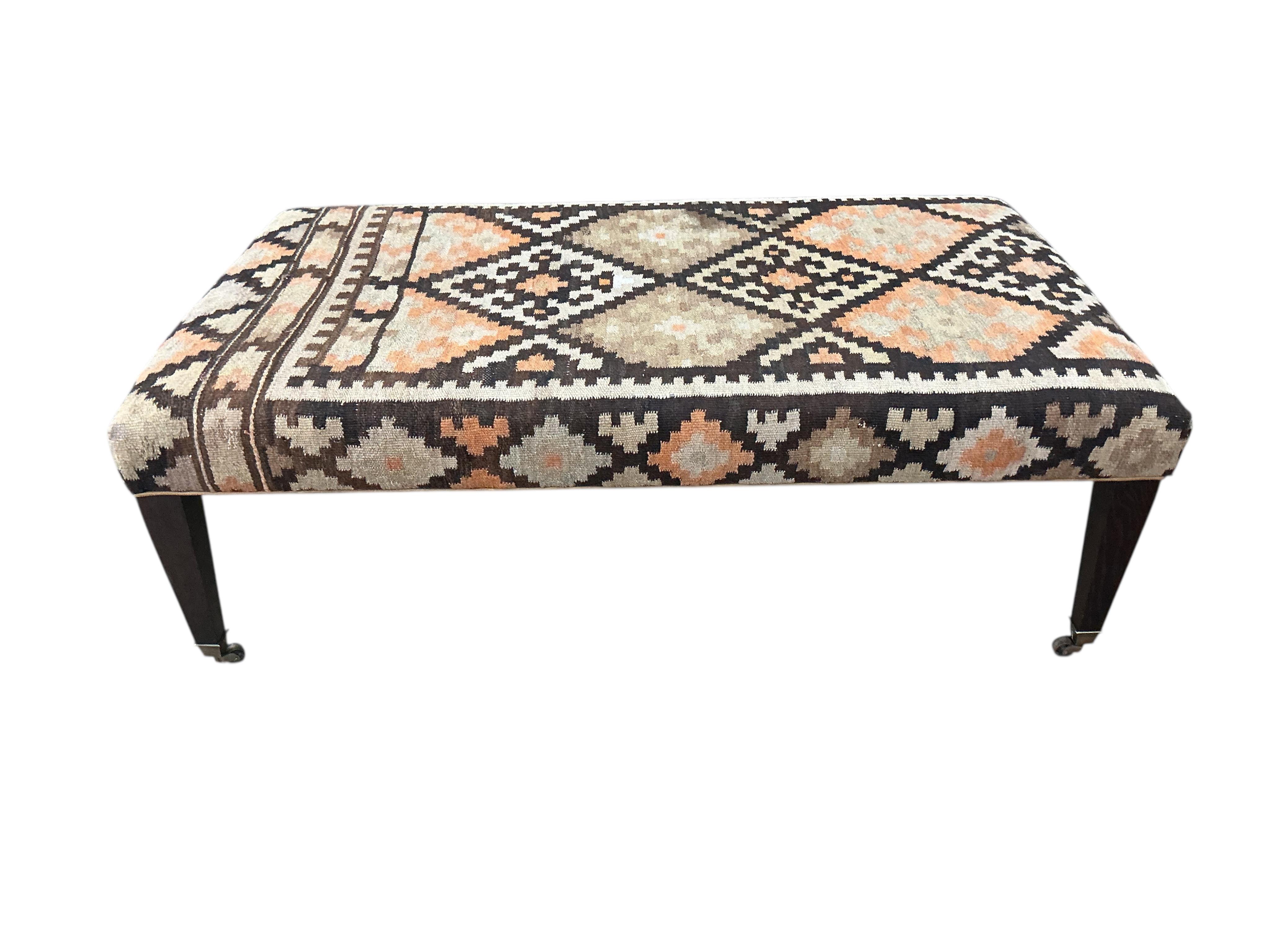 A large rectangular coffee table / footstool with polychrome Kilim upholstered top, width 143cm, depth 84cm, height 48cm